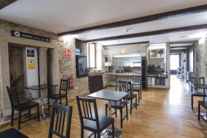 a restaurant with tables and chairs in a room at Hotel Alda Algalia in Santiago de Compostela