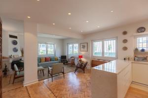 eine Küche und ein Wohnzimmer mit Sofa und Tisch in der Unterkunft FLH Jacaranda Costa Caparica Beach House in Costa da Caparica