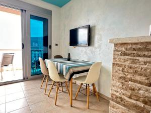 a dining room with a table and chairs and a tv at Vila Jadranka Apartments in Herceg-Novi