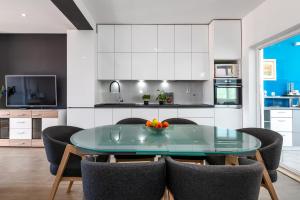 a kitchen with a glass table and chairs at Pool apartman Maja in Šibenik