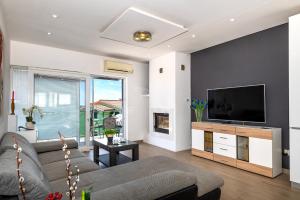 a living room with a couch and a flat screen tv at Pool apartman Maja in Šibenik