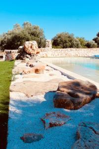 a pool of blue water with rocks in it at Sole Luna Apartments in Monopoli