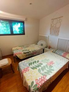 a bedroom with two beds and a window at La Casa de Macarena in Villanueva de la Vera