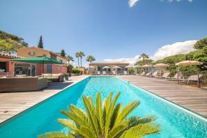 a pool with chairs and umbrellas at a resort at Les Capucines Saint Tropez in Saint-Tropez
