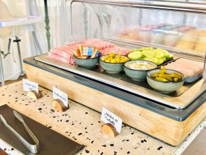a buffet with bowls of food on a table at Les Capucines Saint Tropez in Saint-Tropez