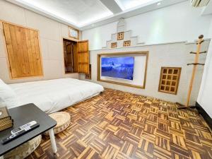 a bedroom with a bed and a flat screen tv at 慢步南國 台南故事民宿 Slow Tainan Homestay in Tainan