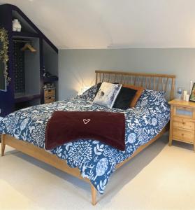 a bedroom with a bed with a blue and white blanket at Willow Barn luxury countryside accommodation in Bury St Edmunds in Bury Saint Edmunds