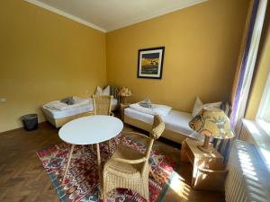 a room with two beds and a table and chairs at Villa am Peetzsee in Schlangenluch