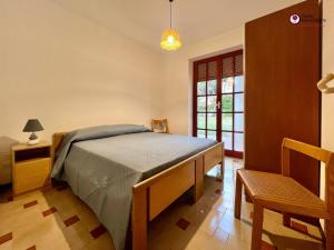 a bedroom with a bed and a chair and a window at Villa Nella - WelcHome in Marina di San Vito