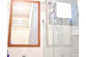a bathroom with a glass shower with a mirror at Manolika Studio 4 in Kithnos