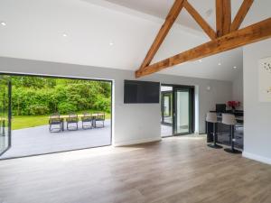 an open living room with a dining area and a large window at Hartgrove Farm Bungalows in Axminster