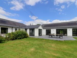 a large white building with a picnic table in the yard at Hartgrove Farm Bungalows in Axminster