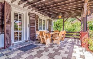 a wooden table and chairs on a patio at Lovely Home In Parzensko With Sauna in Karsko +20 photos