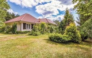a house with a yard with trees and bushes at Lovely Home In Parzensko With Sauna in Karsko