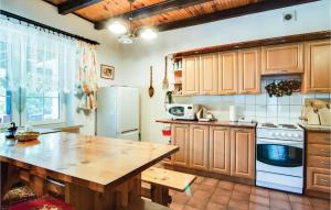 a kitchen with a wooden table and a refrigerator at Lovely Home In Parzensko With Sauna in Karsko