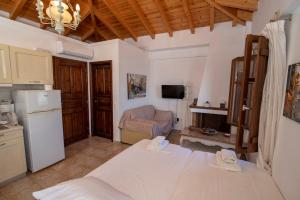 eine Küche und ein Wohnzimmer mit einem Bett und einem Kühlschrank in der Unterkunft ILIOLOUSTA in Kyparíssion