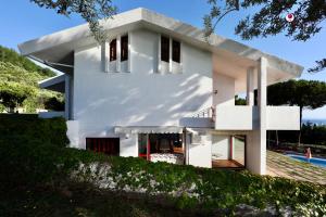 a white house on a hill with a pool at Villa Nella - WelcHome in Marina di San Vito
