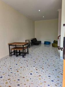 un soggiorno con un tavolo e un divano di Guesthouse Jogja Selatan 2 Yogya South-Bantul Casa de Joy a Gandok