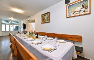 a long table with white plates and wine glasses at Pet Friendly Home In Kapela With Sauna in Kapela