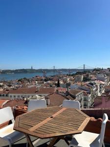 a wooden table and chairs on a roof at Olympo Shared flat with Amazing River view in Lisbon