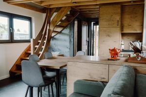 a kitchen and dining room with a wooden table and chairs at Regielskie Chaty in Regiel