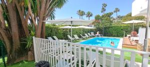 a swimming pool with chairs and umbrellas on a balcony at Résidence Carlton - Rénovée avec Piscine in Beaulieu-sur-Mer