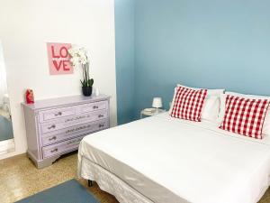a bedroom with a bed with red and white pillows and a dresser at La casa di Ci in Cecina