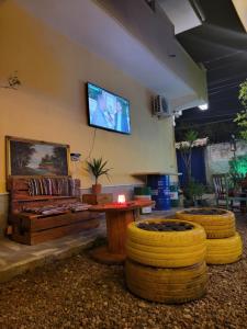 a living room with a couch and a tv on the wall at The Bearded Dad Hostel in Tirana