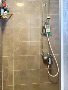 a shower with a hose in a bathroom at Holiday Apartment Hirvas 1 in Saariselka