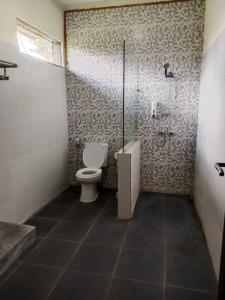 a bathroom with a toilet and a shower at Villa Grya Pengalu in Penginyahan +3 photos