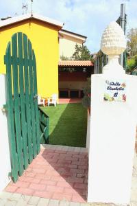 a house with a green gate and a yard at Villetta vista mare a Praialonga in Le Castella