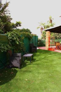 a yard with chairs and a bench on the grass at Villetta vista mare a Praialonga in Le Castella
