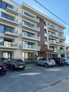 a parking lot with cars parked in front of a building at Nord Residence in Eforie Nord