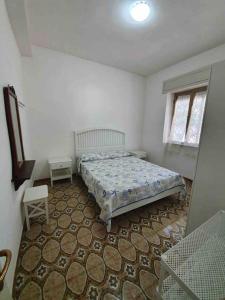a bedroom with a bed and a table and a window at Villa Francesco & Chiara in Torre Colimena