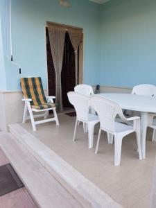 a white table and chairs on a patio at Villa Francesco & Chiara in Torre Colimena