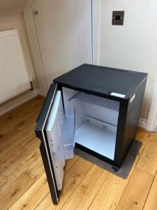 a black tv sitting on the floor next to a door at Spacious and Modern En-suit in Harrow on the Hill