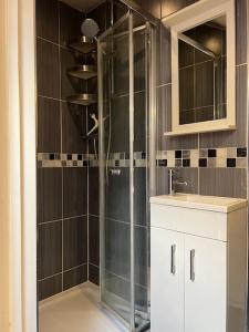 a bathroom with a glass shower and a sink at Spacious and Modern En-suit in Harrow on the Hill