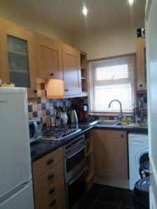 a kitchen with a sink and a stove top oven at Spacious and Modern En-suit in Harrow on the Hill +5 photos