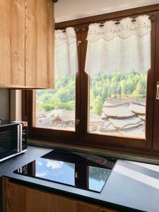 a kitchen with a window with a view of a house at Maison Lalla in Pré-Saint-Didier +27 photos