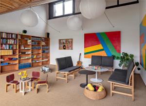 a living room with chairs and a table and bookshelves at Højhuset Kulturhotel in Herning