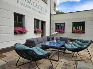 a patio with couches and a table and chairs at Chasa Castello relax & spa in Samnaun