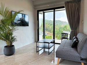 a living room with a couch and a tv at Naiwok Hills Resort in Haad Pleayleam