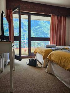 a bedroom with two beds and a large window at Cinéma, Chambre Privée Au Le Refuge Du Phoenix in Échevis