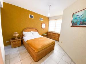 a bedroom with a bed and a yellow wall at Apartamento en tucacas Cocotero mar 2 con la playa a tus pies in Tucacas +28 photos
