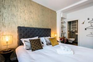 a bedroom with a large white bed with two towels at Luxurious boutique suite in City Center in Amsterdam