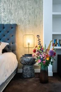 a bedroom with a bed and a table with a vase of flowers at Luxurious boutique suite in City Center in Amsterdam