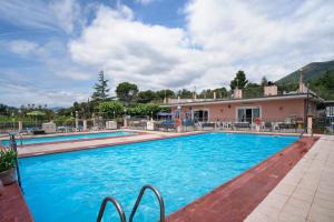 a large swimming pool in front of a house at Monolocale La Pineta 46 in Albenga