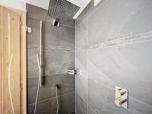 a bathroom with a shower with a shower head at Plein Ciel 118 **** in Verbier +6 photos