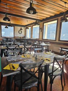 a dining room with tables and chairs and windows at Cinéma, Chambre Privée Au Le Refuge Du Phoenix in Échevis