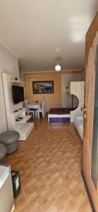 a room with a bed and a living room with a table at Dori 's place in Vlorë
